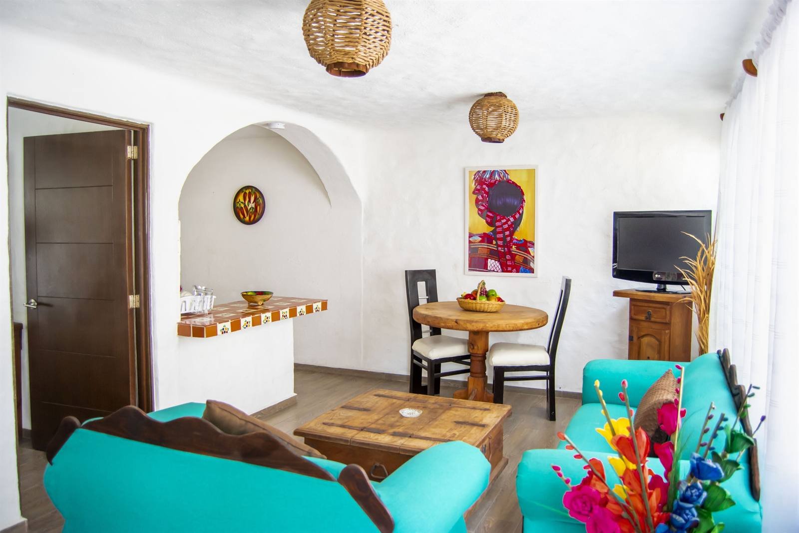 Petit Hotel Pilitas: suite living room with turquoise sofas, a TV and a small dining table