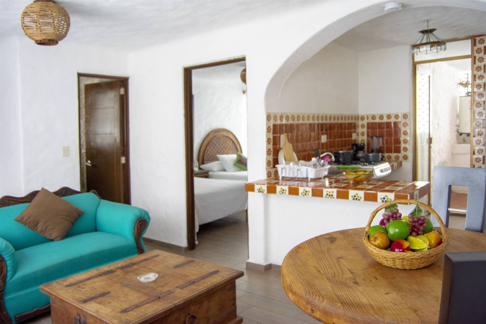Petit Hotel Pilitas: suite with a sitting area, a tiled kitchenette and the bedroom beyond an arch