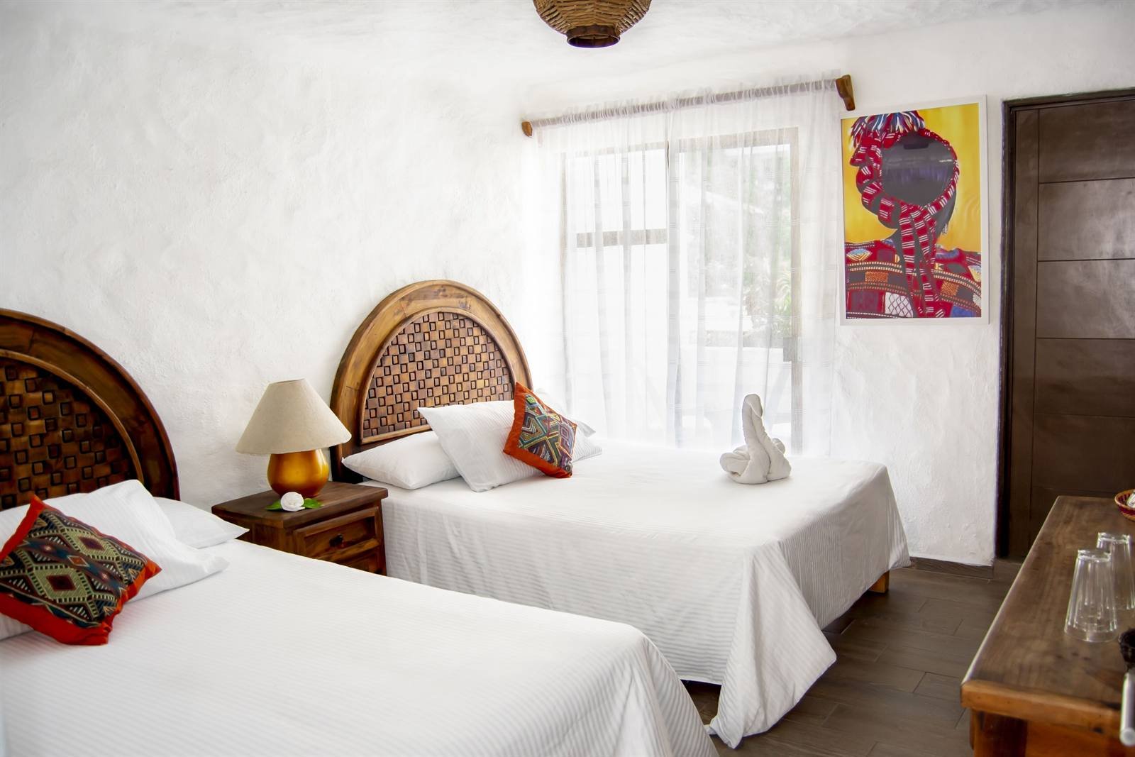 Petit Hotel Pilitas: quadruple suite with two beds and carved wooden headboards
