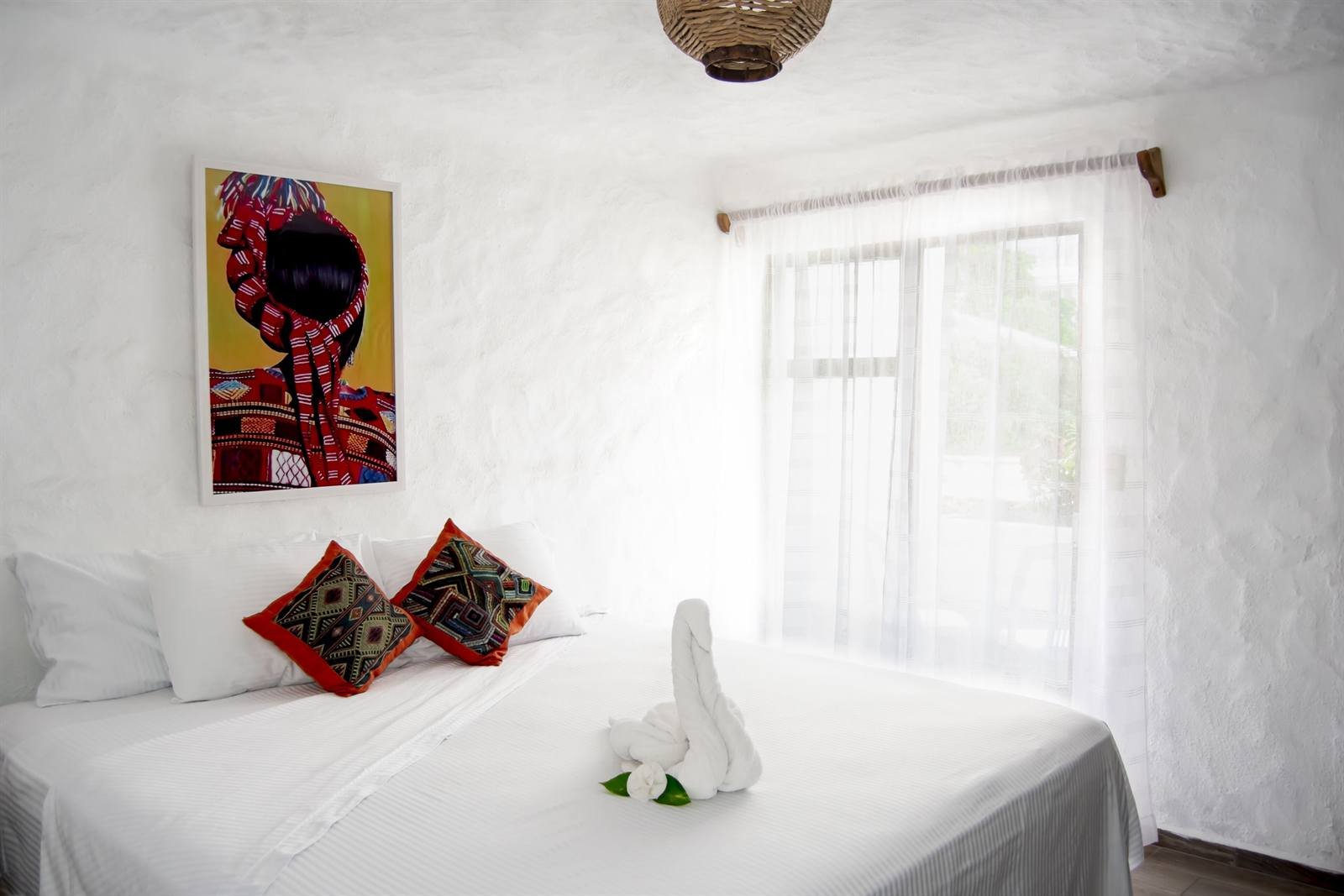 Petit Hotel Pilitas: standard room with a King bed, embroidered cushions and a towel swan